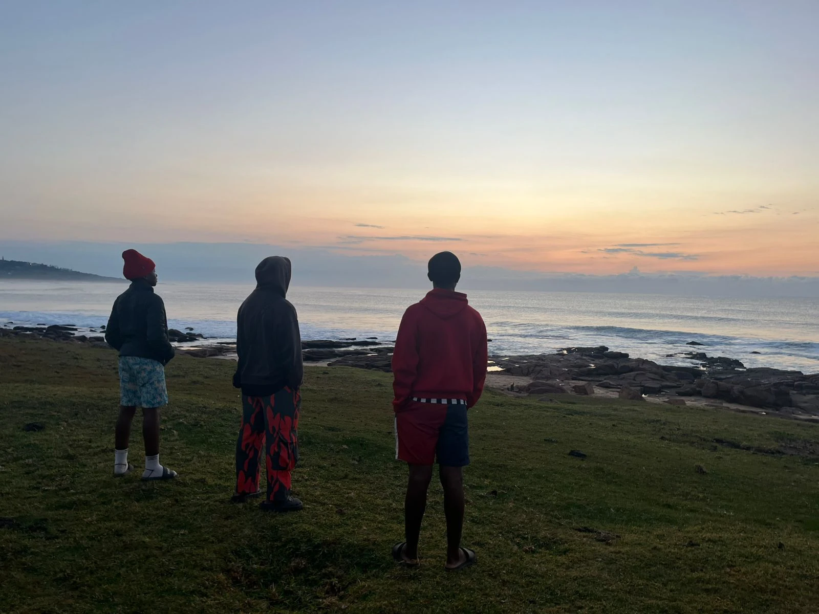 Three USC surfers watching the dawn swell at Umzumbe Point, KwaZulu-Natal